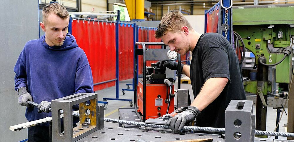 Die Stäbe werden in der LernFabrik von zwei Azubis gebogen