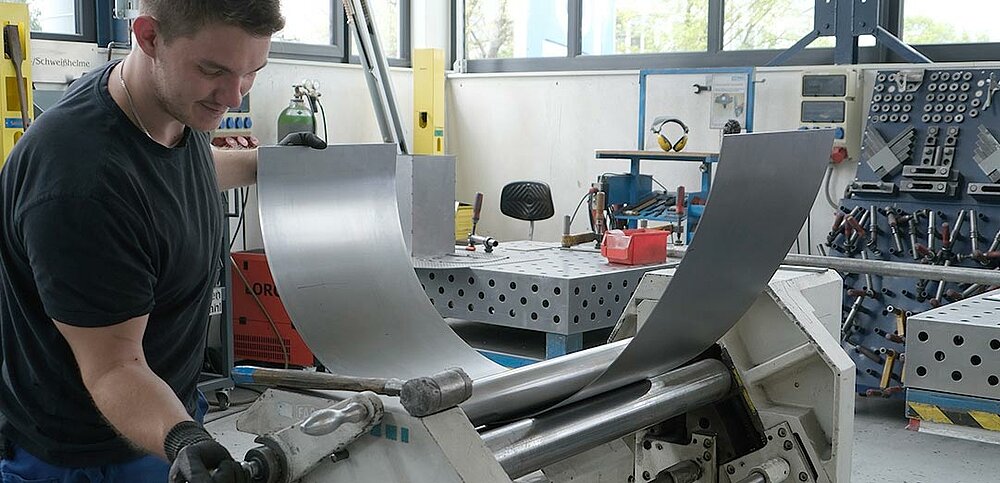 Ein Azubi beim Rundwalzen eines Einzelteils eines Buckstabens