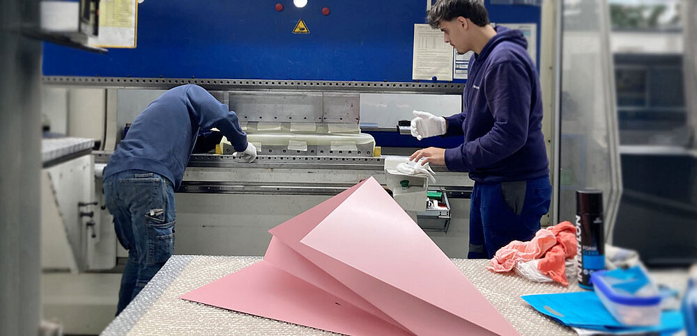 Zwei Personen an Biegemaschine