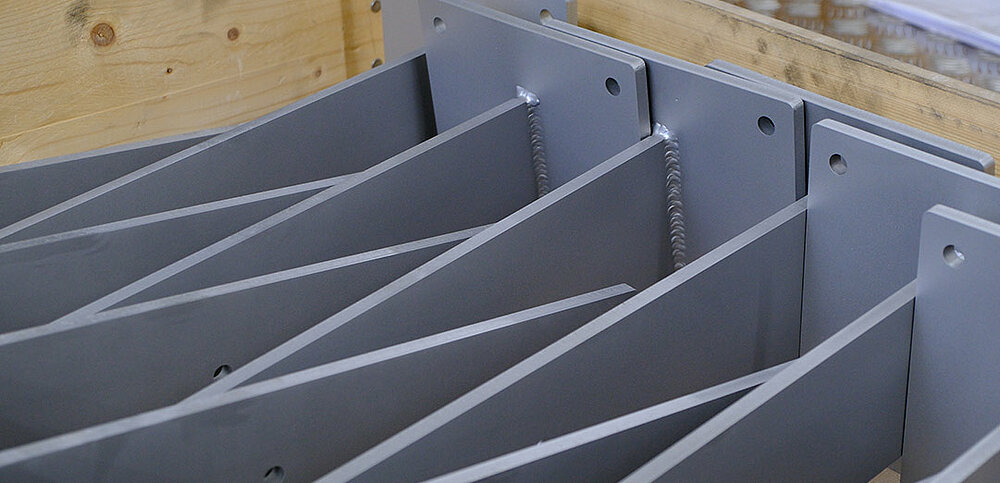 Fertig gepulverte Metallteile in Kiste gestapelt