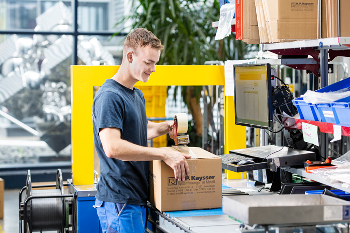 Auszubildender Fachkraft für Lagerlogistik beim Verpacken